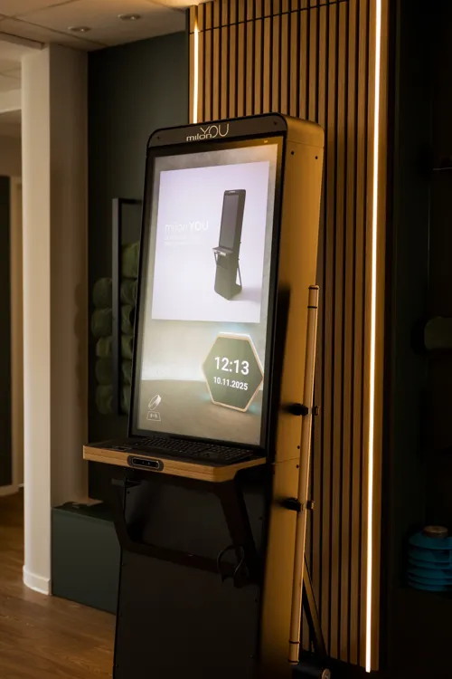 Milon YOU Analysestation vor der Holzwand bei OptiCore
